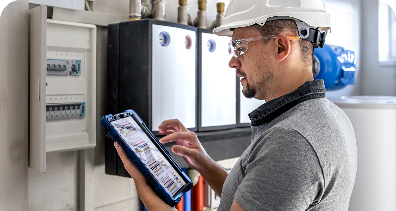 Technician using a tablet near HVAC controls